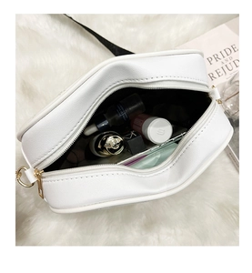 Interior view of white leather crossbody camera bag showing capacity for cosmetics