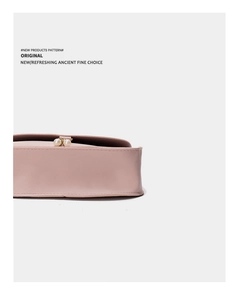 Close-up of pink leather handbag featuring textured grain and twin pearl gold clasps