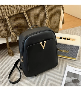 Close-up of black crocodile pattern leather backpack with gold V logo and floral zipper charm