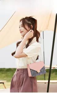 Pink crossbody bag with glitter panels, gold geometric lock and elegant chain strap detail