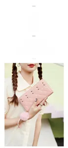 Detailed shot of pink quilted leather wallet with gold studs and a fluffy pompom charm