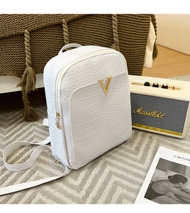 Detailed shot of white faux crocodile leather backpack with elegant golden V hardware