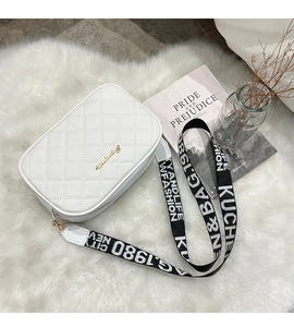 Detailed shot of white quilted crossbody bag with stylish wide letter-printed strap