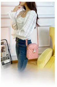 Crossbody phone bag in pink quilted PU leather with cute rabbit buckle on female model