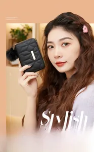 Detailed view of black quilted PU wallet with gold metal bar and fur pompom accessory