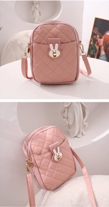 Detail of pink quilted crossbody phone bag with a cute white rabbit metal clasp