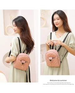 Detailed view of pink quilted mini backpack with star tassel and metallic charm