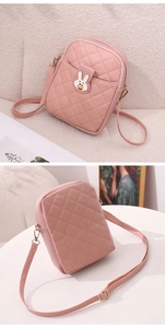 Detail view of pink quilted crossbody phone bag with cute white rabbit metal buckle closure