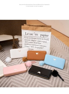 Long gloss wallets in five colors featuring metal butterfly logo and fluffy pom pom charm
