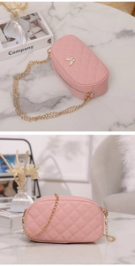 Détail du sac en cuir matelassé rose avec breloque papillon et bandoulière dorée