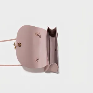 Minimalist light pink crossbody bag showing interior layout and magnetic metal buckle closure