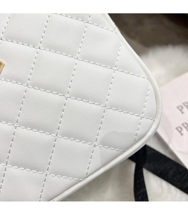 Close-up of white quilted leather texture with gold hardware and fine stitching detail