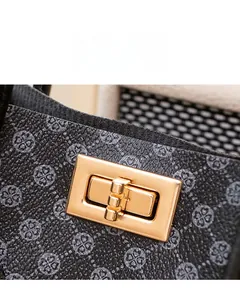 Macro shot of elegant gold rectangular hardware lock on printed leather handbag detail