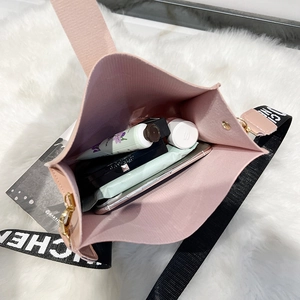 Sac seau rose en cuir grainé avec large bandoulière montrant la capacité intérieure