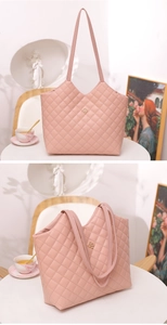 Detailed close-up of pink quilted tote bag with a golden floral emblem decoration