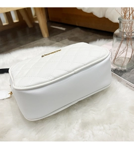 Top view of white quilted cross-body bag with gold zipper and metal logo on faux fur