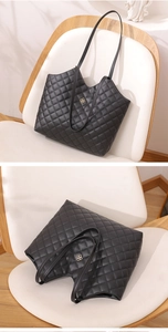 Close-up of black quilted tote bag featuring diamond pattern and gold clover hardware