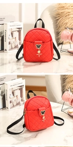 Macro shot of red quilted leather backpack with Mickey-shaped metal buckle and straps