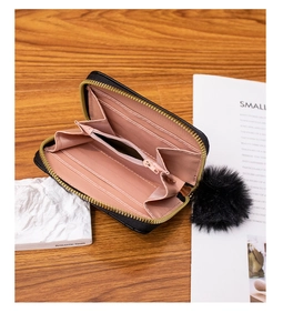 Interior view of black zip wallet featuring pink card slots and a central coin compartment