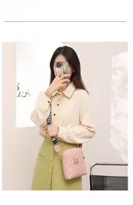 Detail of pink geometric crossbody mini bag with wide patterned strap and buckle closure