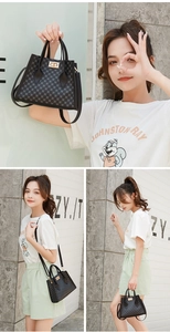 Detail view of a black printed handbag featuring a gold square lock and shoulder strap