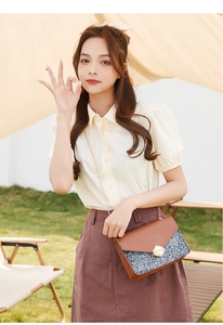 Close-up of sequin crossbody bag with gold chain and metal lock in outdoor setting