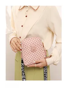 Detail of pink monogrammed crossbody bag with golden clasp and branded fabric strap