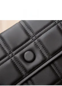 Dettaglio della texture in pelle trapuntata nera e del fermaglio rivestito in pelle