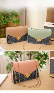 Detail shot of shimmering sequin chain bags in pink, beige, and mint on a wooden table