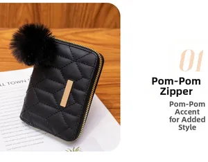 Detail of black quilted mini purse featuring fuzzy pom-pom keychain and gold zipper