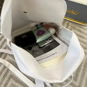 White crocodile pattern backpack showing spacious interior storage and textured leather
