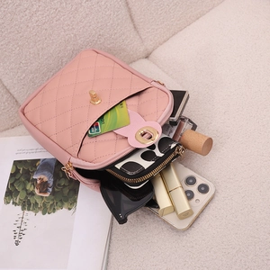 Pink quilted crossbody bag with gold lock on soft fleece background showing storage capacity