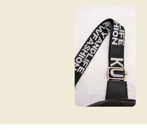 Détail de la sangle jacquard avec texte LIFE FASHION et boucle en métal doré sur sac noir