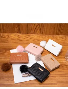 Detailed display of quilted short wallets with metal accents and pompom charms in five colors