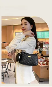 Détail du sac d'épaule matelassé noir avec plaque dorée et mini pochette ronde