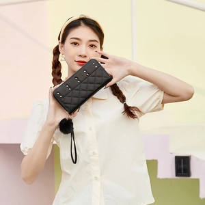 Pochette matelassée en similicuir noir avec clous dorés, pompon et dragonne amovible