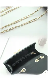 Detail of black quilted shoulder bag featuring gold chain strap and inner zipper pocket