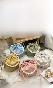 Detail of colorful pearl handle bucket bags in five pastel colors with drawstring design