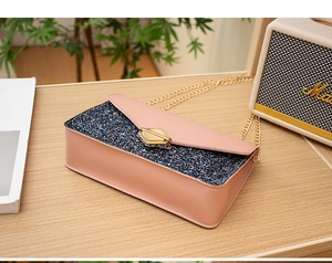 Detail of pink crossbody bag featuring sequin patchwork and a gold geometric lock