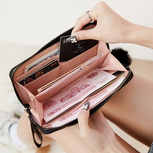 Black long leather wallet for women with pink interior and decorative pompom charm
