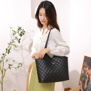 Chic black quilted leather tote bag with gold clover logo for women shopping or daily use