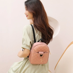 Pink quilted PU leather mini backpack with metal Mickey charm shown on female model