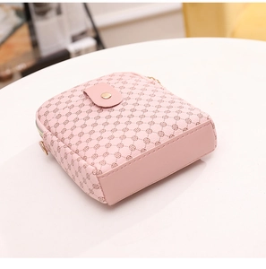 Detail view of pink crossbody bag with geometric floral pattern and gold hardware