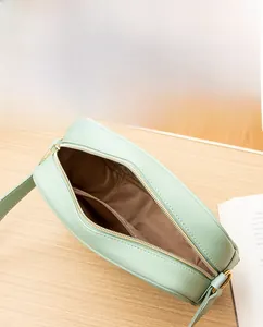 Interior view of mint green leather handbag showing spacious compartment and zipper pocket