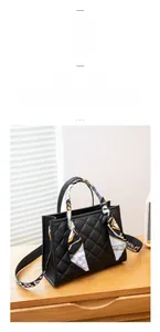 Detail of black quilted tote bag with silk scarf handle and wide textile shoulder strap