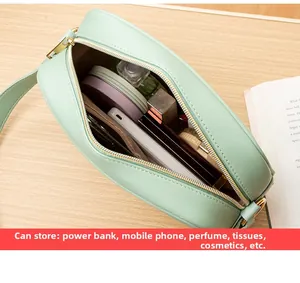 Top view of spacious mint green handbag interior with pockets on light wooden desk