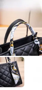 Close-up of quilted black leather bag featuring silk scarf wrapped handle and fine stitching