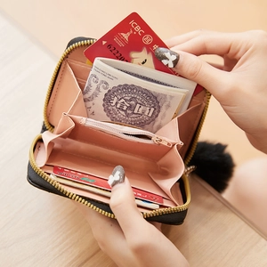 Quilted black leather mini wallet with pink interior and fluffy pom-pom charm