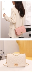 Macro detail of quilted crossbody bags in pink and beige with golden chain straps