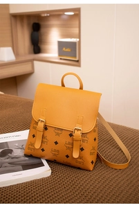 Dettaglio dello zaino in pelle giallo zenzero con motivo monogramma e fibbie decorative
